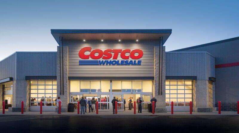 Costco warehouse exterior with a red and white logo, entrance doors, shopping carts.